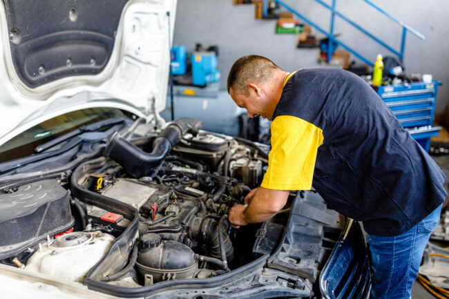 mężczyzna sprawdza silnik w samochodzie